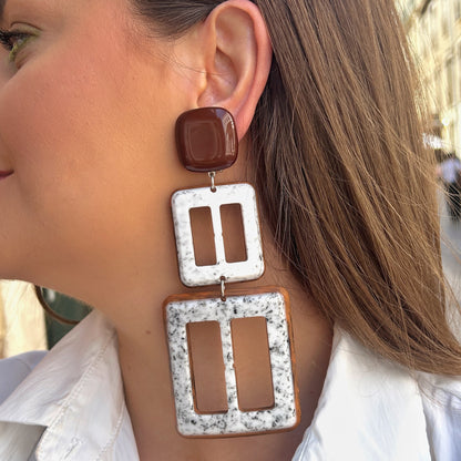 Boucles Lolita Double Francine Bramli Paris en résine marron brillante et marbrée blanche avec design graphique XXL ajouré.