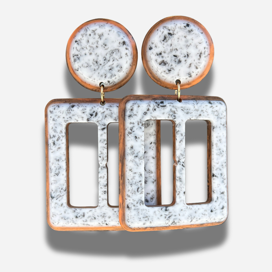 Boucles Lolita Simple Francine Bramli Paris en résine marbrée blanche et noire avec contour brun caramel et design géométrique ajouré.