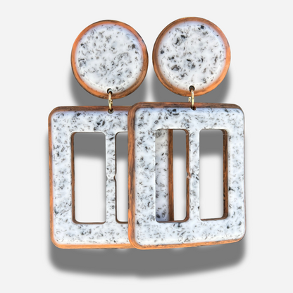 Boucles Lolita Simple Francine Bramli Paris en résine marbrée blanche et noire avec contour brun caramel et design géométrique ajouré.