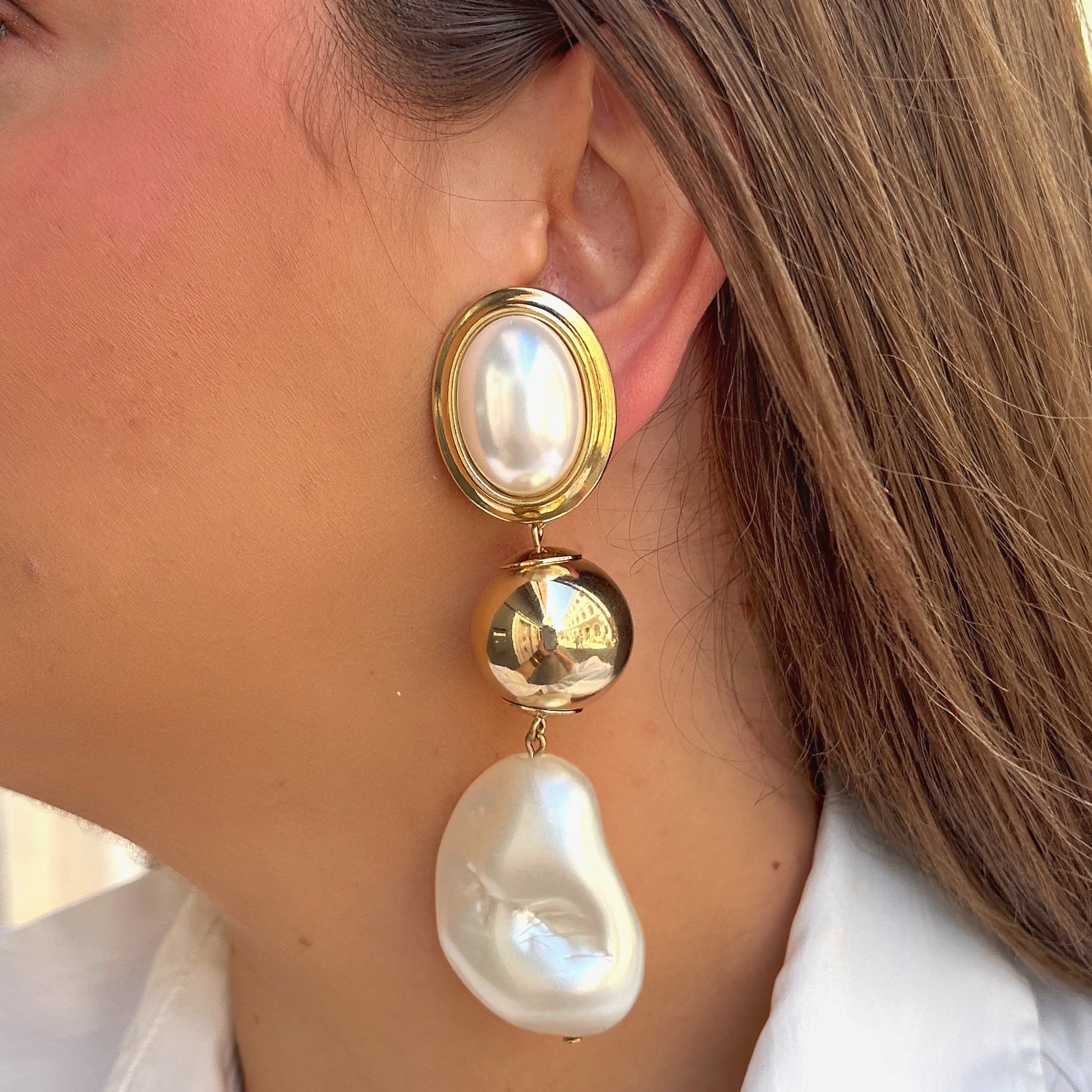 Boucles Lydie Perles Francine Bramli Paris avec cabochon nacré ovale, boule dorée miroir et perle baroque blanche suspendue.