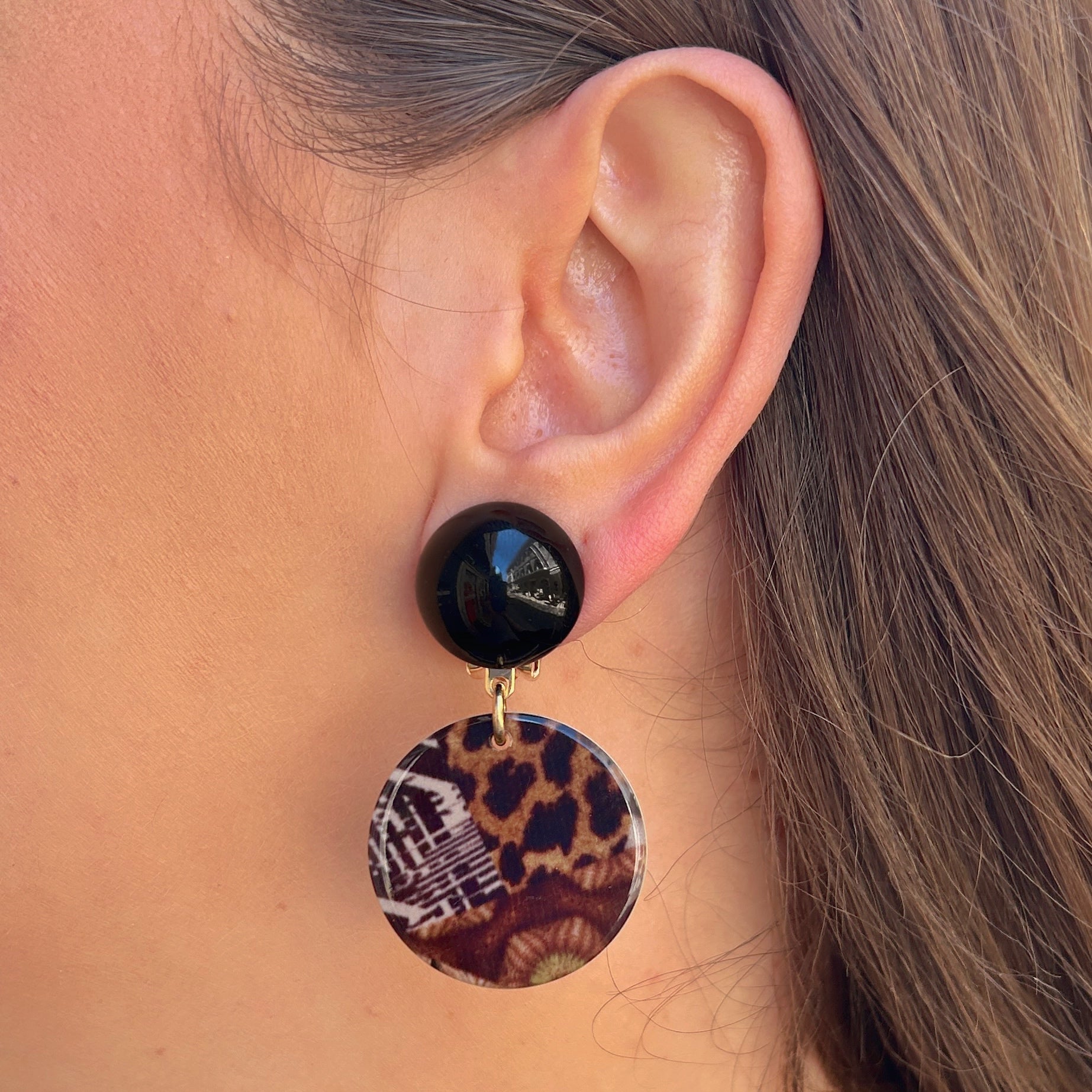 Boucles Maila Safari Francine Bramli Paris avec cabochon noir brillant et médaillon rond imprimé léopard dans des tons marron et noir.