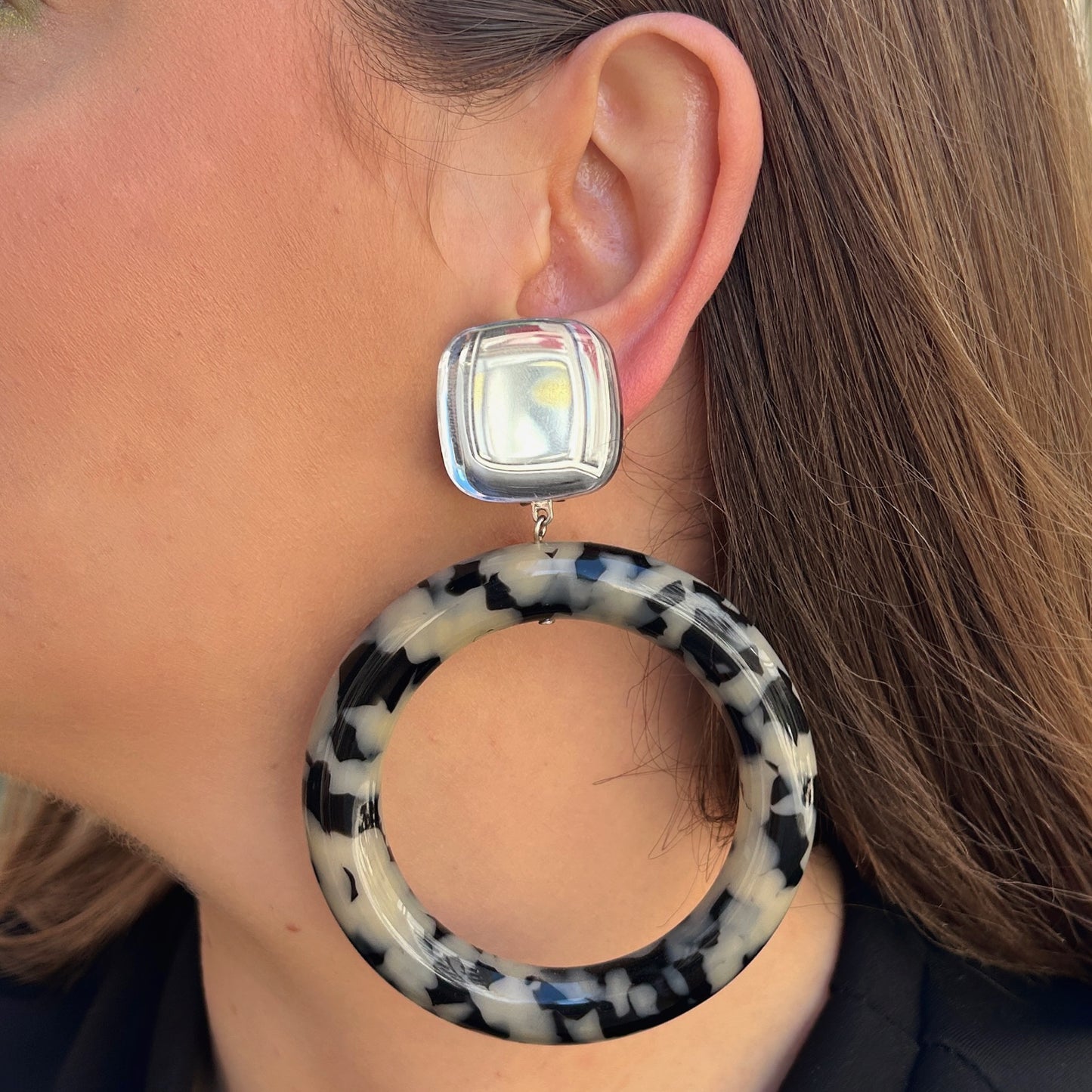 Boucles Marge Écaille Noir et Blanc Francine Bramli Paris avec grand anneau en résine marbrée noire et blanche et cabochon argenté