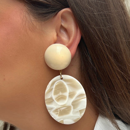 Boucles Mathilda Alba Francine Bramli Paris en résine ivoire nacrée avec pendentif ovale marbré crème.