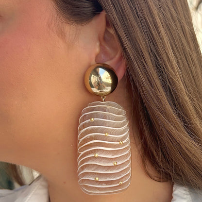 Boucles Ondara Francine Bramli Paris en résine nude texturée avec détails dorés et puce ronde miroir dorée, portées sur mannequin chez Divinity Sète.