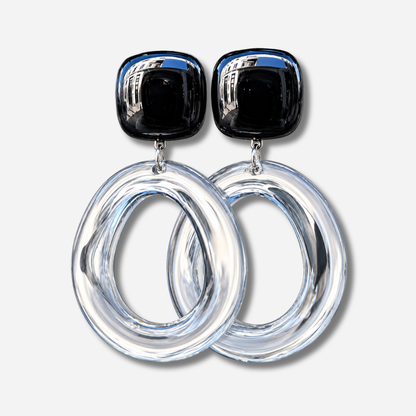 Boucles d’oreilles Abyssa Noir à clips Francine Bramli Paris, cabochons carrés noirs brillants et grands anneaux ovales transparents.