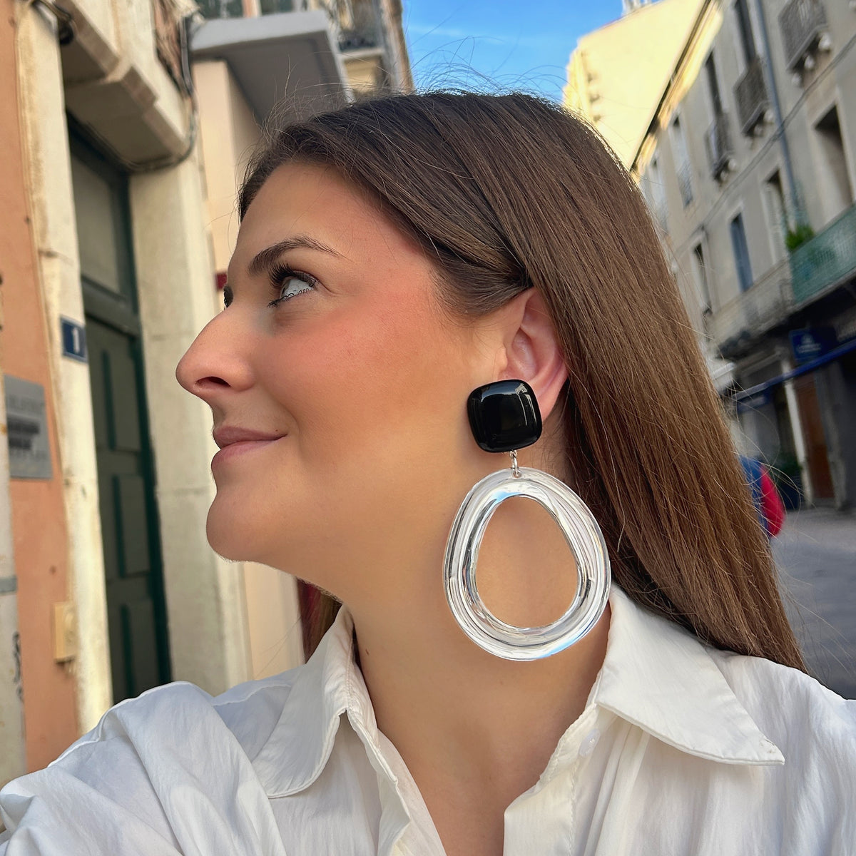 Boucles d’oreilles Abyssa Noir à clips Francine Bramli Paris, cabochons carrés noirs brillants et grands anneaux ovales transparents.