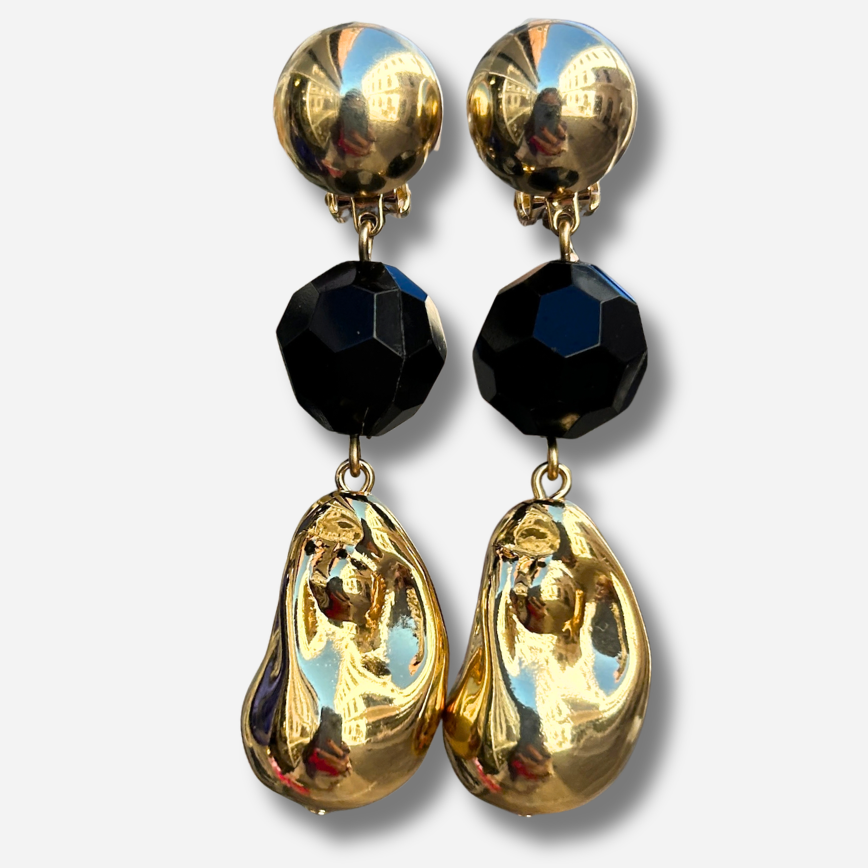 Boucles d'oreilles à clips Anastatia Noir Gold Francine Bramli Paris avec bouton rond doré effet miroir, perle noire facettée et pendentif goutte sculptural doré brillant – Divinity Sète.