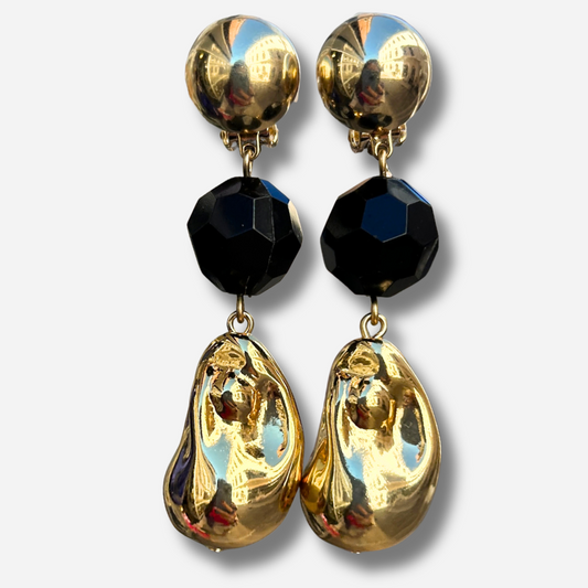 Boucles d'oreilles à clips Anastatia Noir Gold Francine Bramli Paris avec bouton rond doré effet miroir, perle noire facettée et pendentif goutte sculptural doré brillant – Divinity Sète.
