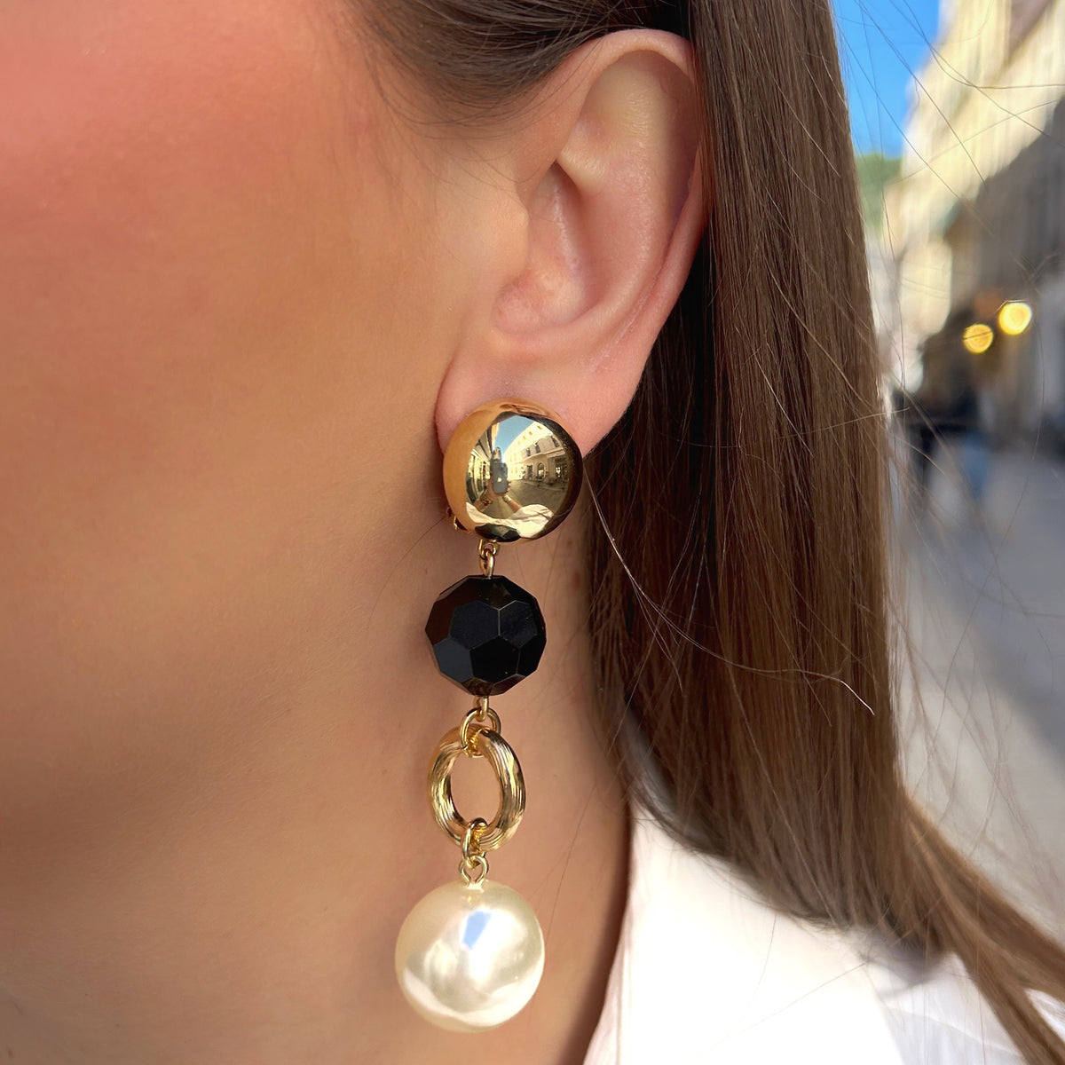 Boucles d'oreilles à clips Anastatia Perles Noir Francine Bramli Paris avec bouton rond doré effet miroir, perle noire facettée, anneau ovale doré et grande perle nacrée ivoire – Divinity Sète.