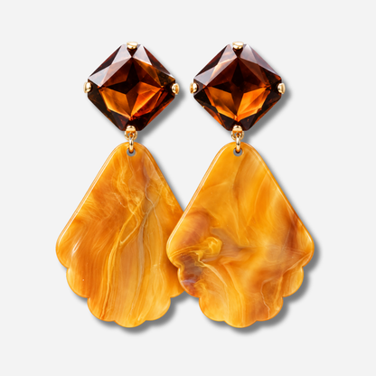 Boucles d’oreilles Aria à clips Francine Bramli Paris avec cabochons carrés facettés brun ambré et grands pendentifs orange marbré aux contours festonnés.