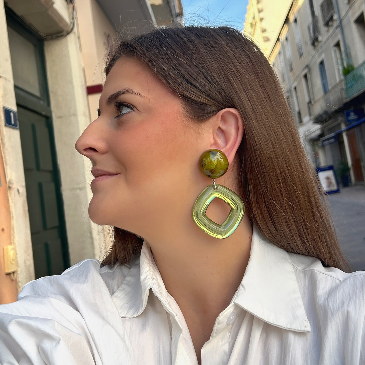 Boucles d’oreilles Asteria Vert à clips Francine Bramli Paris, cabochons ronds marbrés vert olive et grands pendentifs carrés ajourés translucides vert anis, chez Divinity Sète.