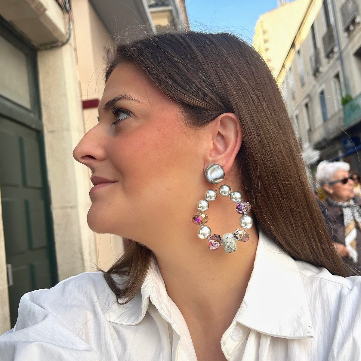 Boucles d’oreilles Bastille Silver à clips Francine Bramli Paris, grands anneaux composés de perles argentées, cristaux facettés irisés et perles minérales grises, disponibles chez Divinity Sète.