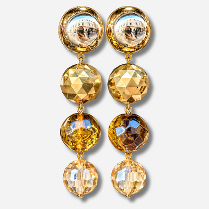 Boucles d’oreilles Cascade Kaki à clips Francine Bramli Paris, cabochons dorés effet miroir et trois perles rondes facettées aux nuances kaki, ambre et champagne.