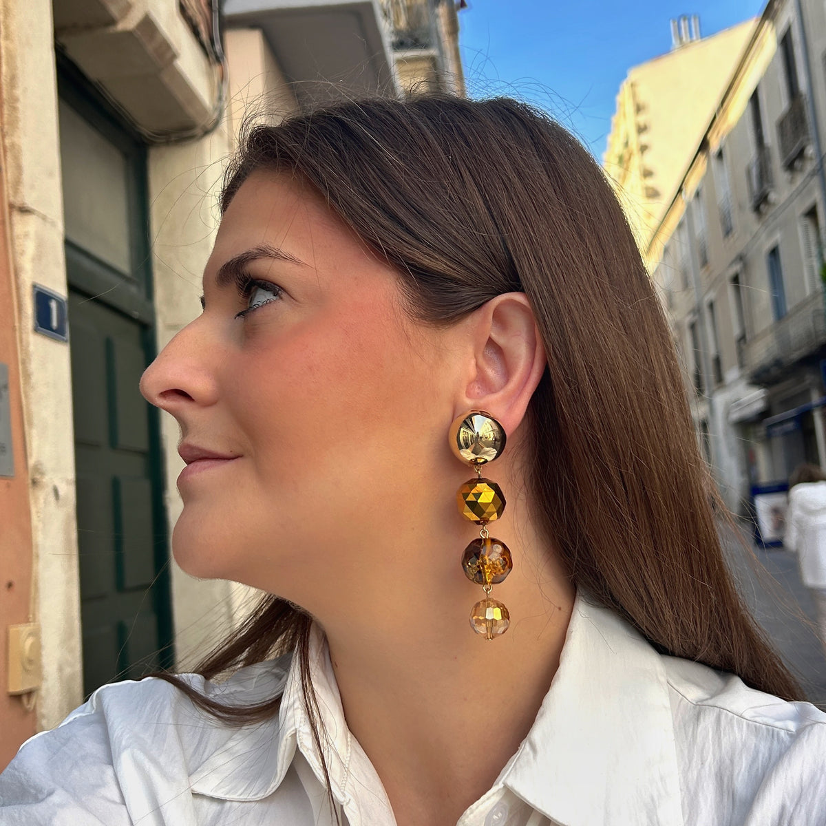 Boucles d’oreilles Cascade Kaki à clips Francine Bramli Paris, cabochons dorés effet miroir et trois perles rondes facettées aux nuances kaki, ambre et champagne.