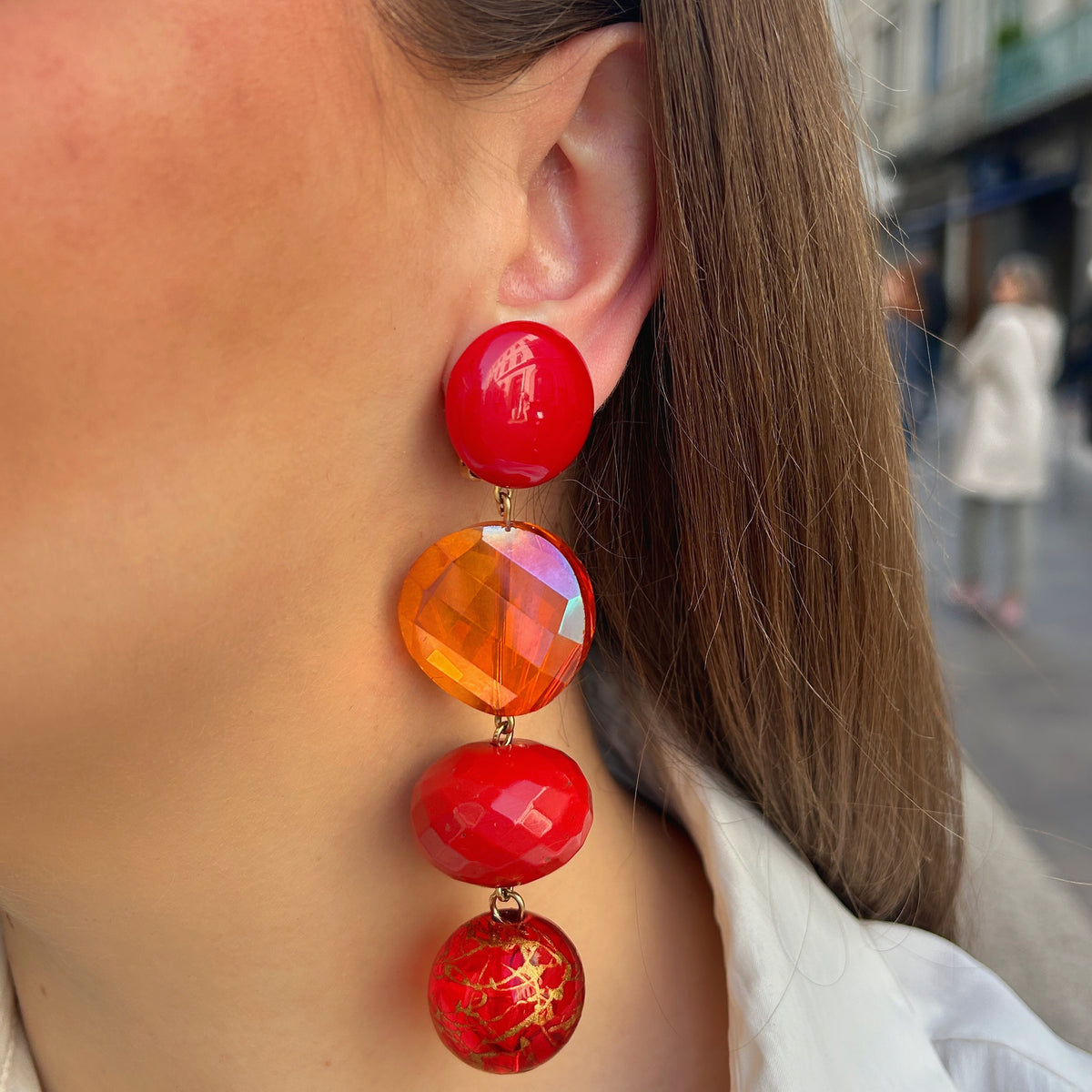 Boucles d’oreilles Cascade Rouge Cristal à clips Francine Bramli Paris, cabochons rouges brillants, cristaux orange facettés et perles rouges aux détails dorés.