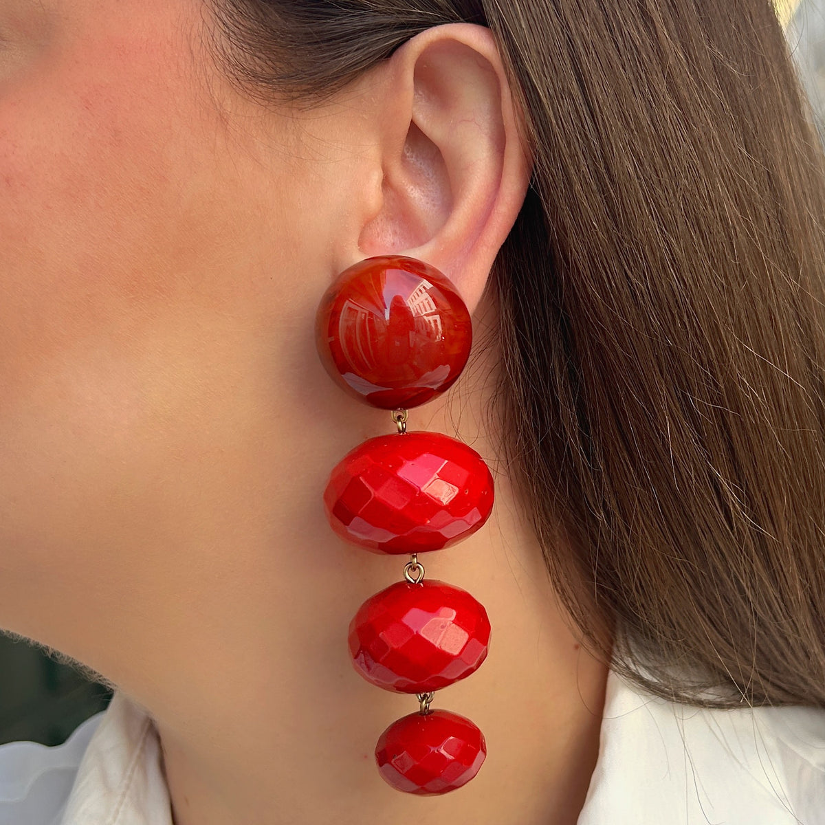 Boucles d’oreilles Cascade Rouge à clips Francine Bramli Paris, cabochons ronds rouge orangé et trois perles ovales rouges facettées.