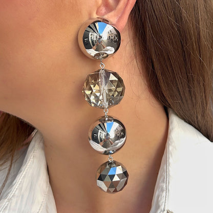 Boucles d'oreilles à clips Cascade Silver Francine Bramli Paris composées de sphères argentées effet miroir et de grosses perles facettées transparentes et gris métallisé, montées en cascade verticale – Divinity Sète.