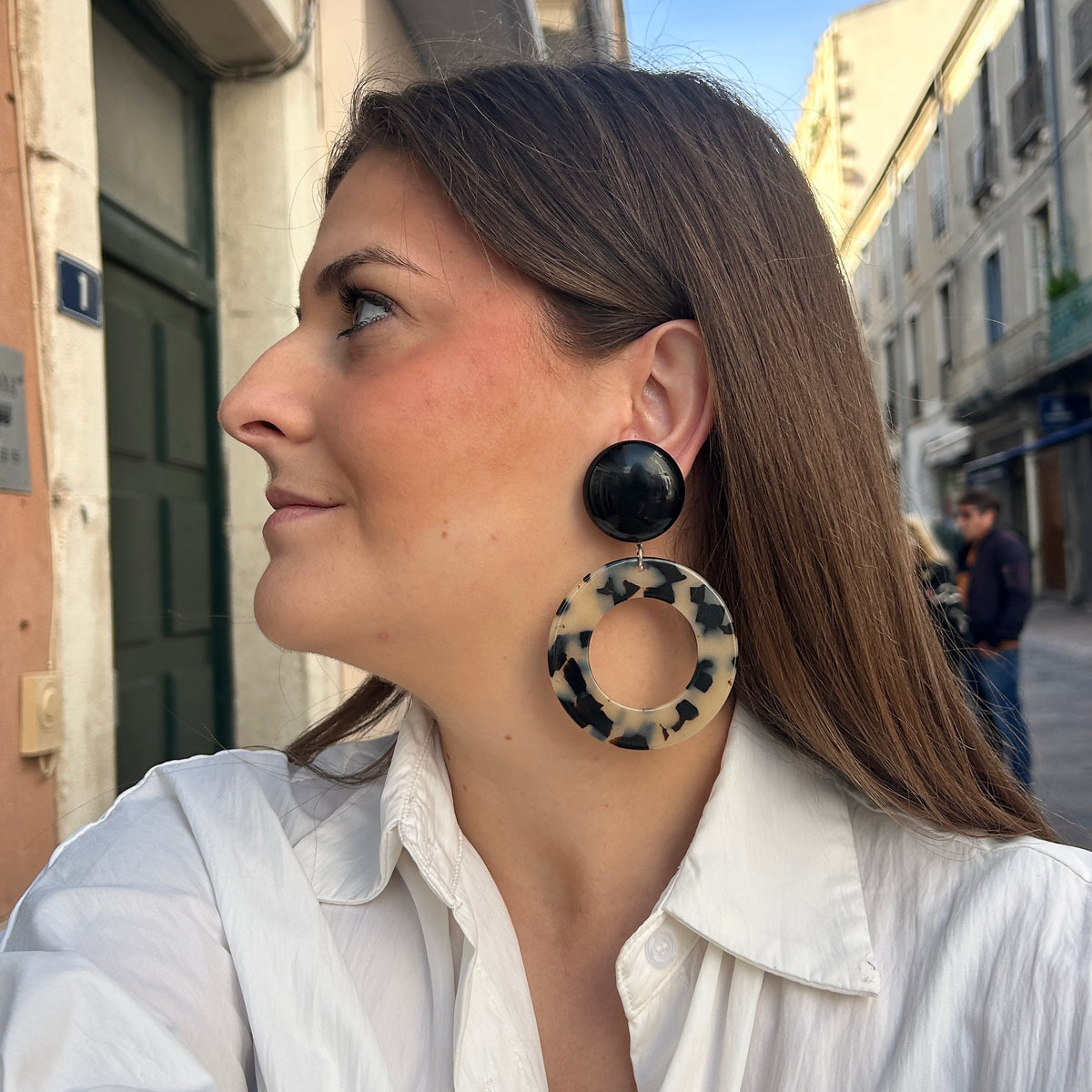 Boucles d’oreilles Cecilia à clips Francine Bramli Paris avec cabochons ronds noirs brillants et grands anneaux ajourés écaille noir et blanc.