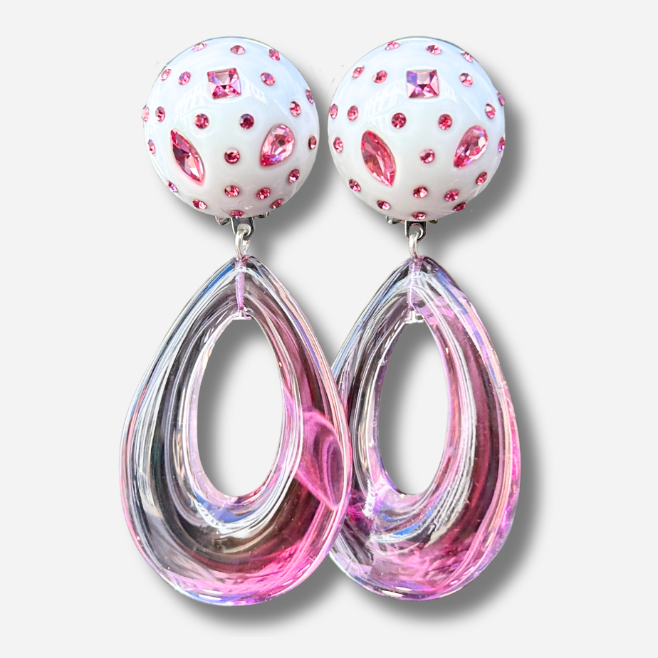 Boucles d'oreilles à clips Céleste Rose Francine Bramli Paris, attaches rondes blanches ornées de strass roses et pendentifs gouttes ajourées en résine rose translucide – Divinity Sète.