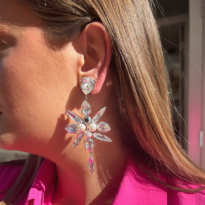 Boucles d'oreilles Celyna Silver à clips Crézus, modèle floral argenté composé de cristaux transparents facettés en forme de goutte et de navette, de trois perles blanches centrales et d'une pampille en cristal suspendue.