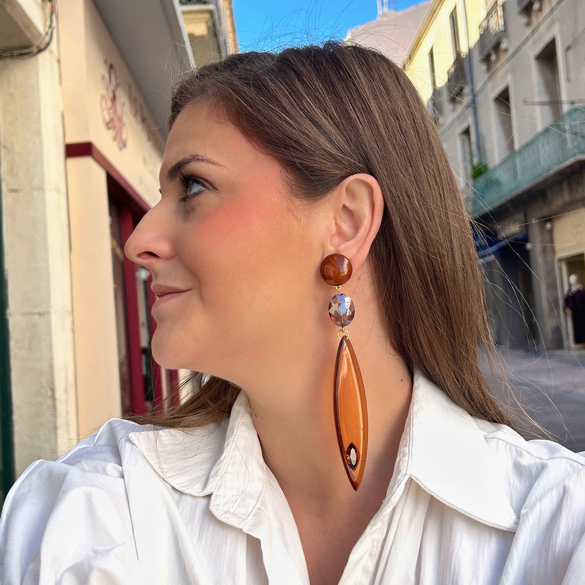 Boucles d’oreilles à clips Plume Marron Francine Bramli Paris, longues plumes en résine translucide ambrée et cristal marron – Divinity Sète.