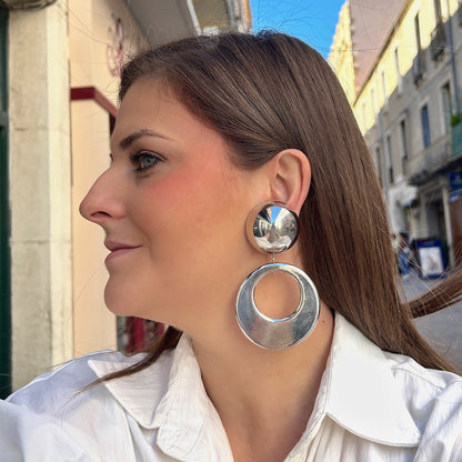 Boucles d'oreilles à clips Cloe Silver Francine Bramli Paris en résine argentée effet miroir, composées d'un gros bouton rond bombé et d'un large pendentif circulaire ajouré à finition métallisée brillante – Divinity Sète.