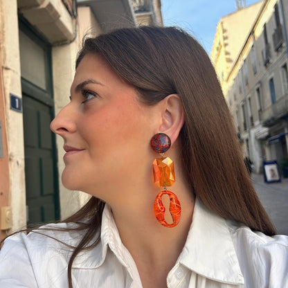 Boucles d’oreilles Dorivique Orange à clips Francine Bramli Paris, cabochons marbrés rouge et noir, cristaux rectangulaires orange facettés et pendentifs ovales ajourés.