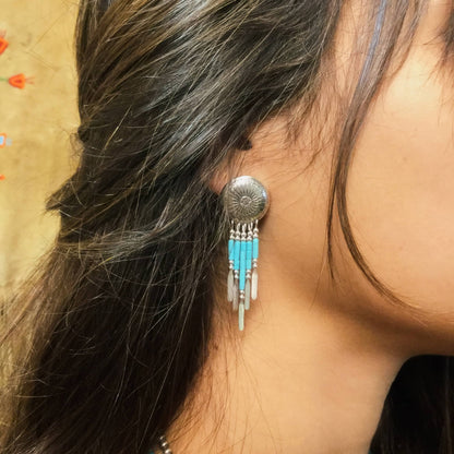 Boucles d’oreilles E310 Concha Turquoise Harpo en argent massif avec médaillons concha gravés, perles turquoise et pampilles en liquid silver.