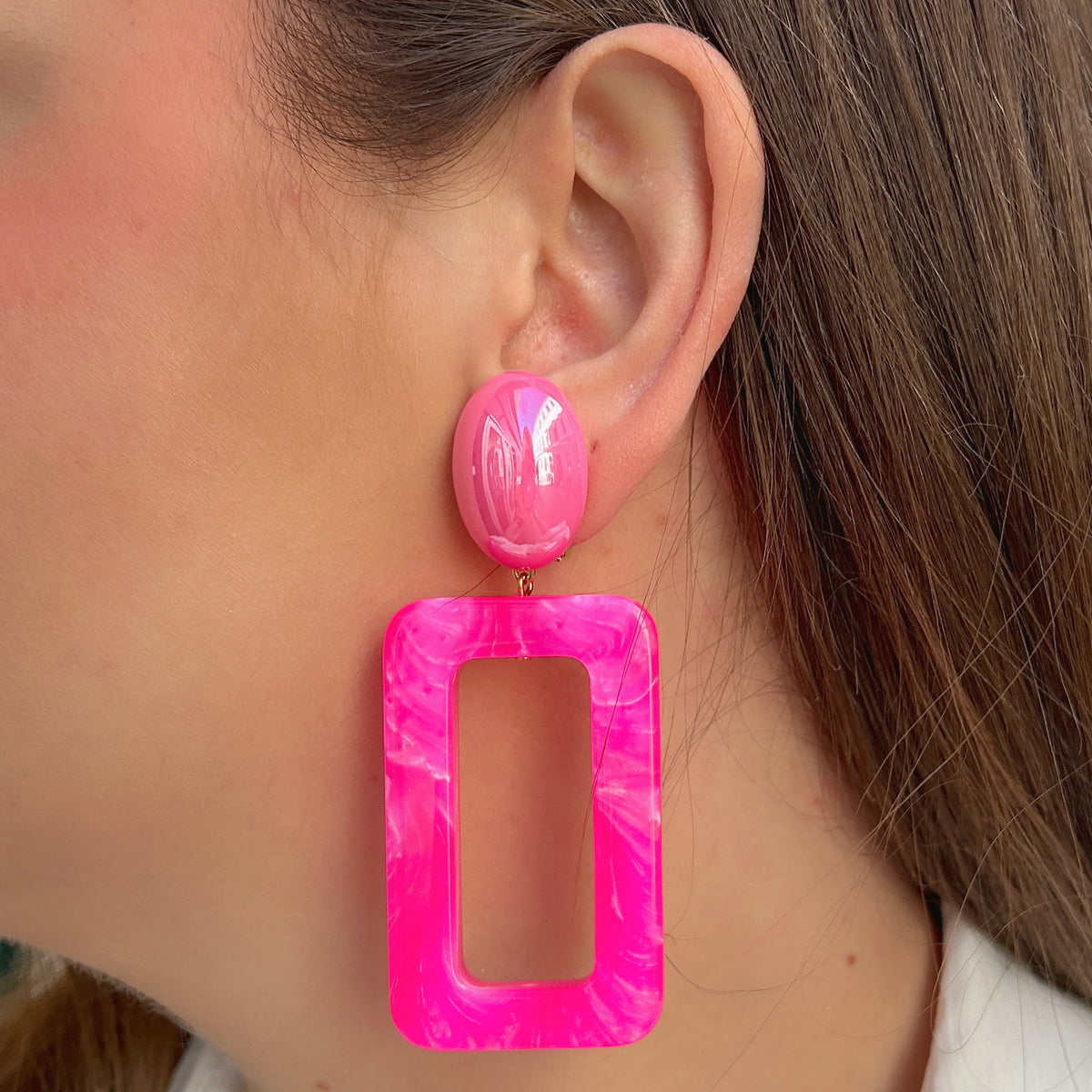 Boucles d'oreilles à clips Estelle Rose Francine Bramli Paris, clips ovales rose fuchsia et grands pendentifs rectangulaires ajourés en résine rose marbrée – Divinity Sète.