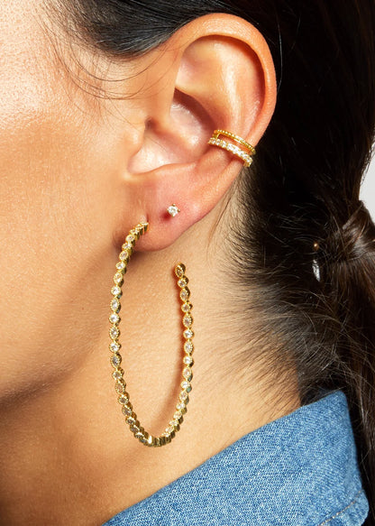 Grandes boucles d’oreilles Great Infinity MYA BAY dorées, ornées d’une succession de cristaux blancs ronds et marquises, disponibles chez Divinity Sète.