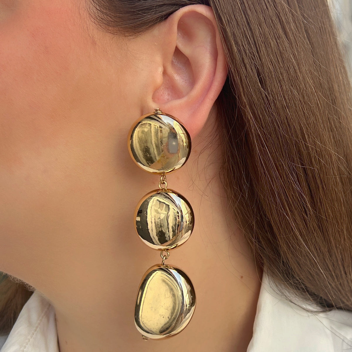 Boucles d’oreilles Mado Gold à clips Francine Bramli Paris, trois éléments bombés dorés effet miroir reliés par des anneaux.