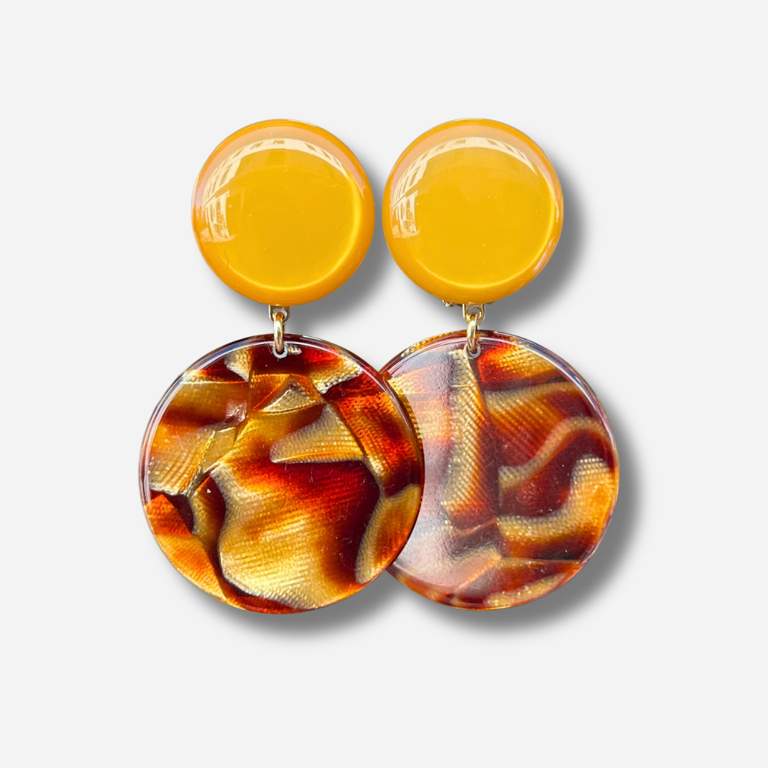 Boucles d'oreilles à clips Maila Feu Francine Bramli Paris, clips ronds jaune orangé et grands pendentifs circulaires en résine transparente aux motifs rouge feu, orange et doré – Divinity Sète.
