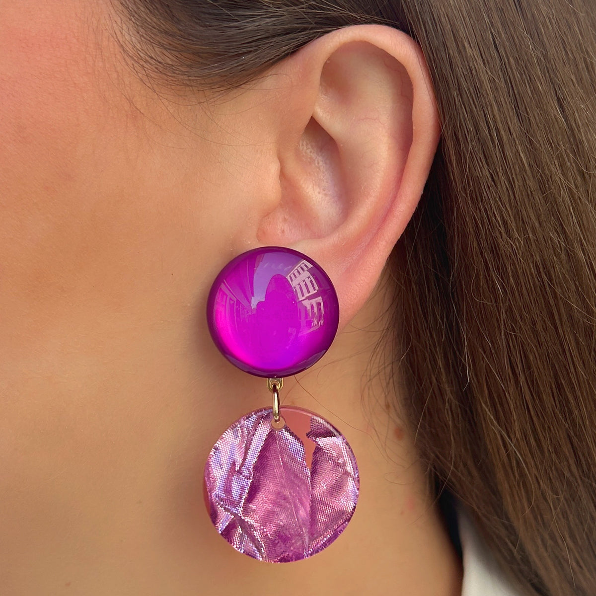 Boucles d’oreilles Maila Violet à clips Francine Bramli Paris, cabochons ronds violet fuchsia brillant et pendentifs circulaires rose métallisé texturé.