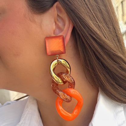 Boucles d’oreilles Maillons Orange Francine Bramli Paris avec maillons oversize orange, doré et pailleté