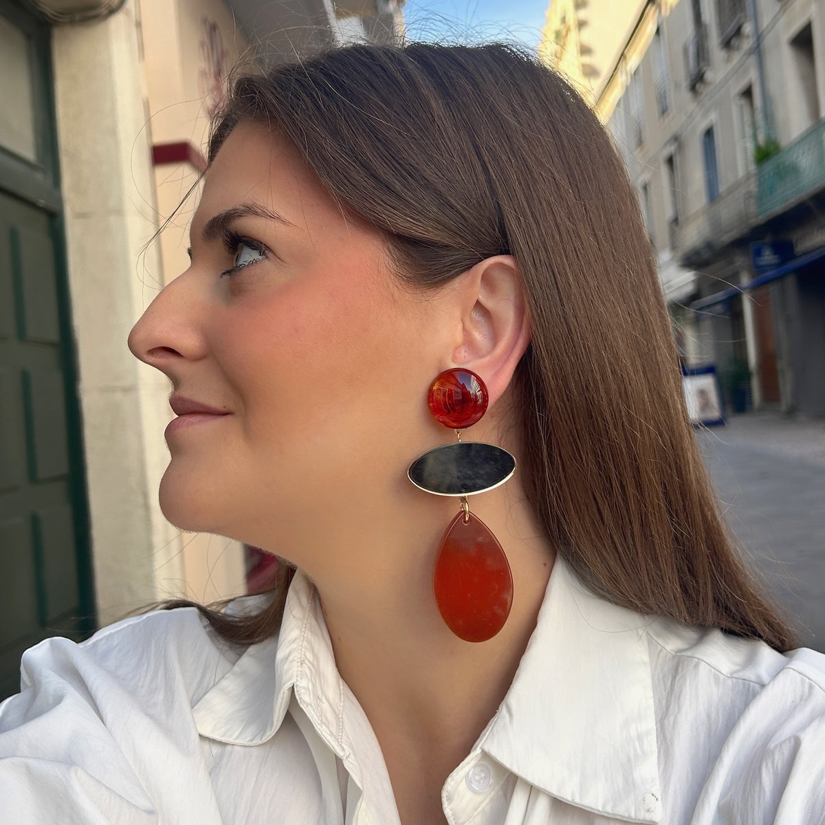 Boucles d’oreilles Marselline Marron à clips Francine Bramli Paris, cabochons ronds ambrés, ovales dorés effet miroir et grandes gouttes en résine orange cuivré.
