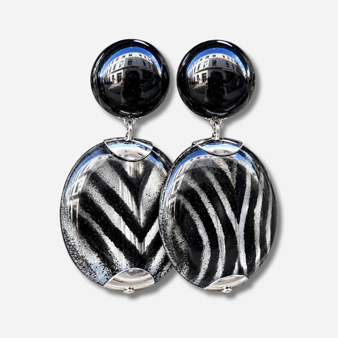 Boucles d’oreilles Mina Rayures à clips Francine Bramli Paris, cabochons noirs brillants et grands pendentifs ronds aux rayures noires et argentées.