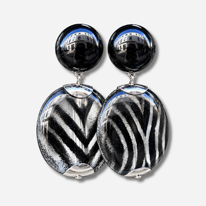 Boucles d’oreilles Mina Rayures à clips Francine Bramli Paris, cabochons noirs brillants et grands pendentifs ronds aux rayures noires et argentées.
