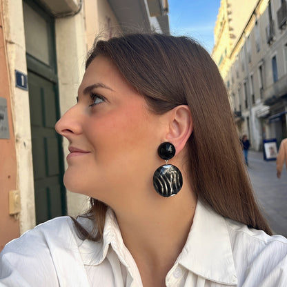 Boucles d’oreilles Mina Rayures à clips Francine Bramli Paris, cabochons noirs brillants et grands pendentifs ronds aux rayures noires et argentées.