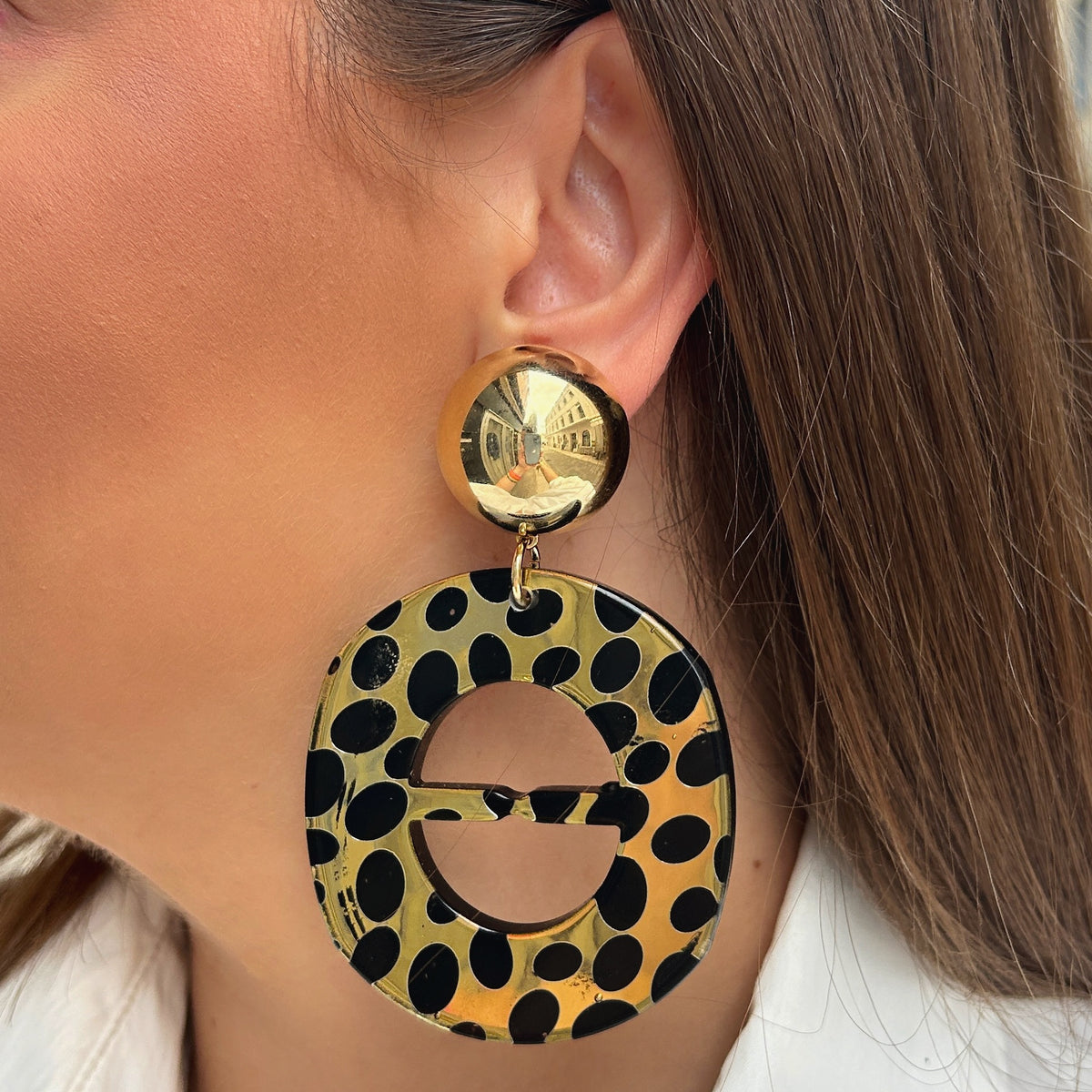 Boucles d'oreilles Nala Gold Francine Bramli en résine dorée à pois noirs avec puce ronde effet miroir