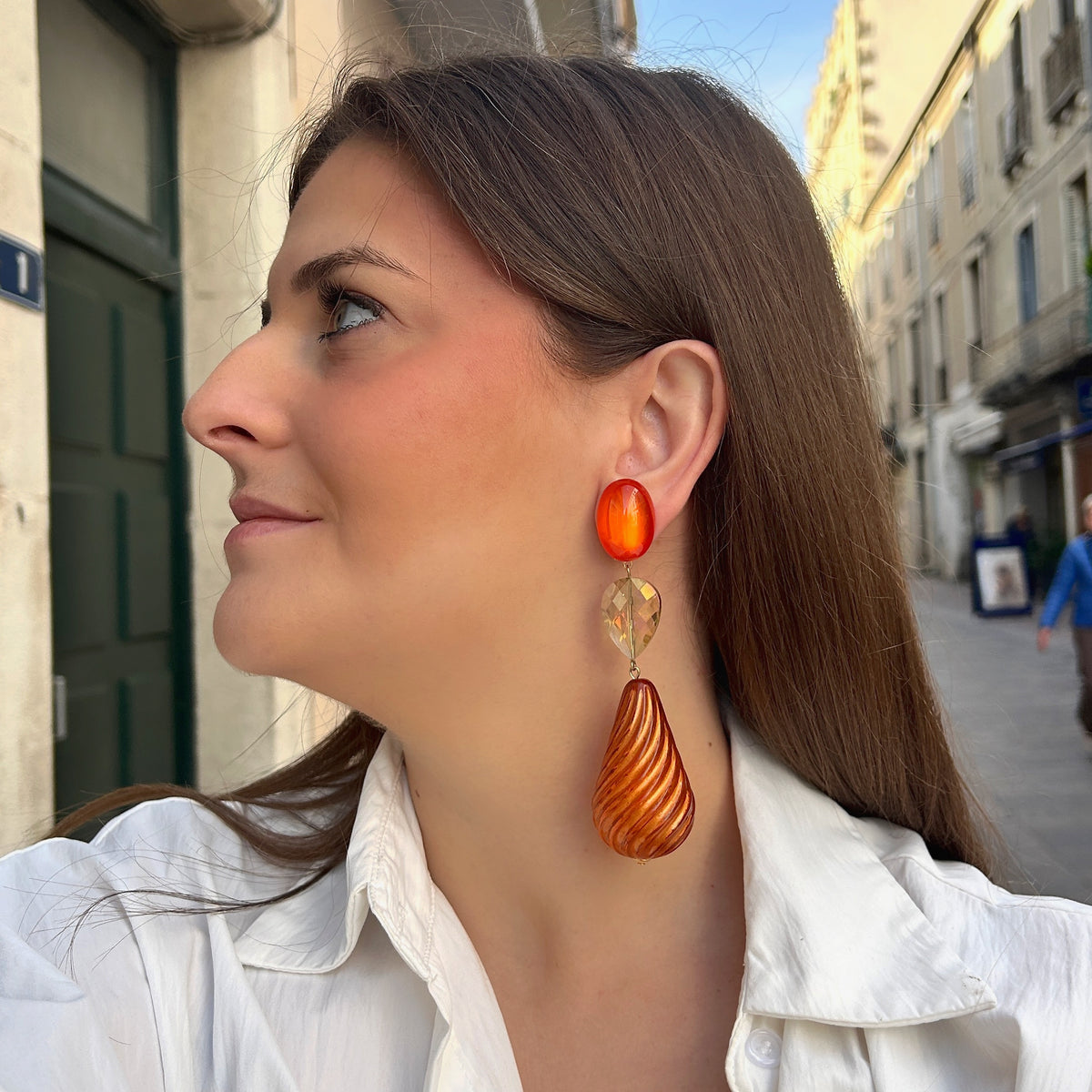 Boucles d’oreilles Pénélope Orange à clips Francine Bramli Paris, cabochons ovales orange, perles gouttes irisées et pendentifs torsadés ambrés.