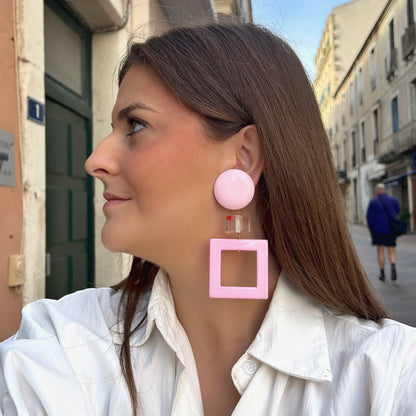 Boucles d’oreilles à clips Reya XL Rose Francine Bramli Paris, cabochons ronds roses, cylindres transparents avec petits cœurs et pendentifs carrés ajourés.