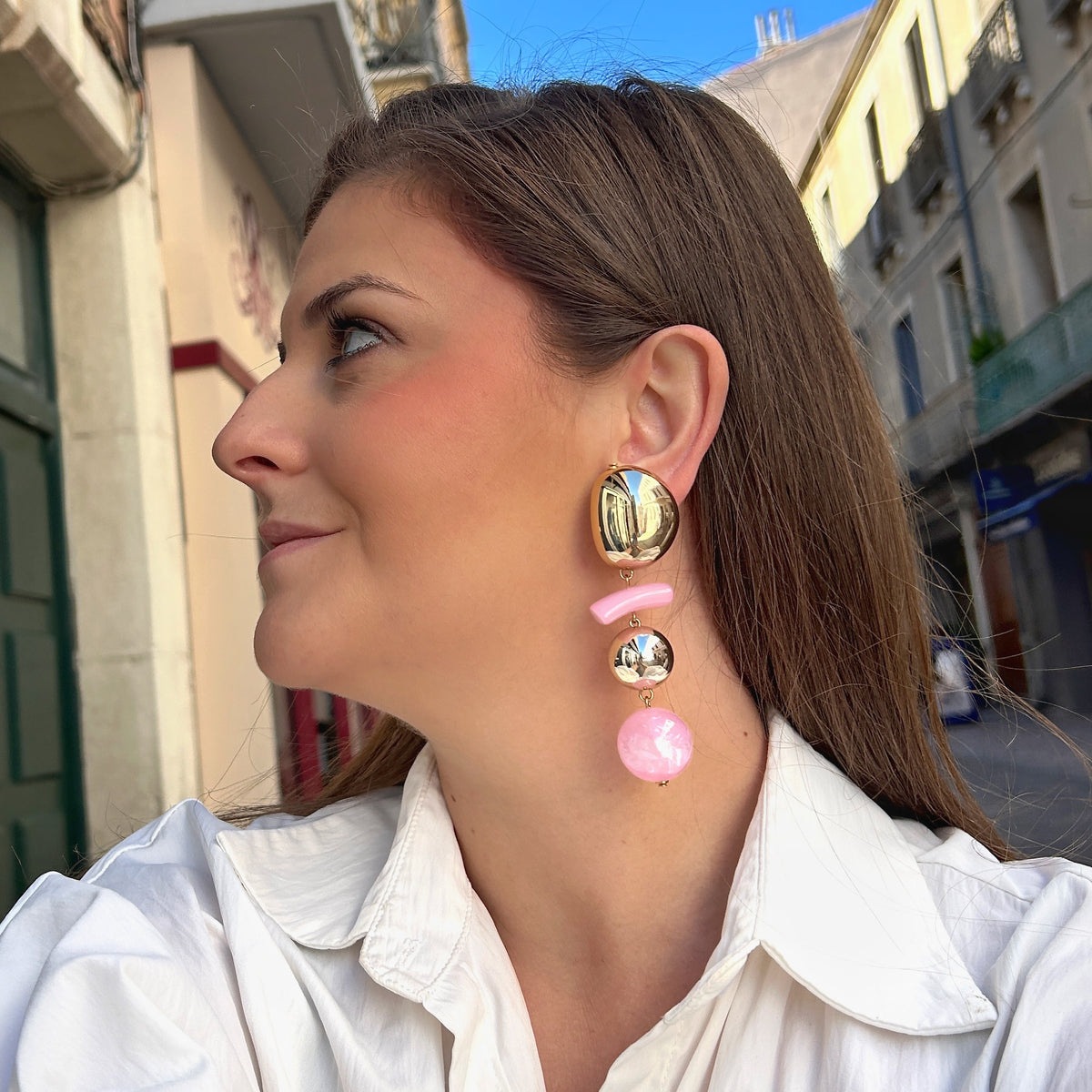 Boucles d'oreilles à clips Rosalia Rose M Francine Bramli Paris avec bouton ovale doré effet miroir, élément incurvé en résine rose pastel, perle ronde dorée et perle rose nacrée – Divinity Sète.