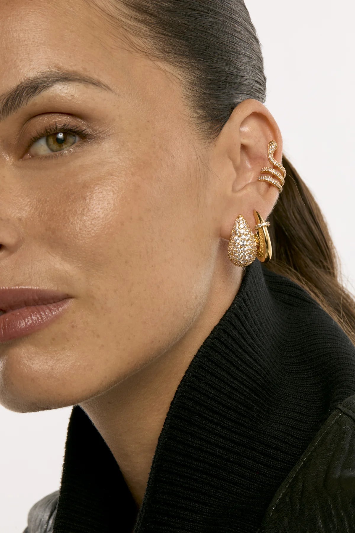 Boucles d’oreilles Shiny Icon MYA BAY dorées en forme de goutte, entièrement pavées de cristaux blancs scintillants, disponibles chez Divinity Sète.