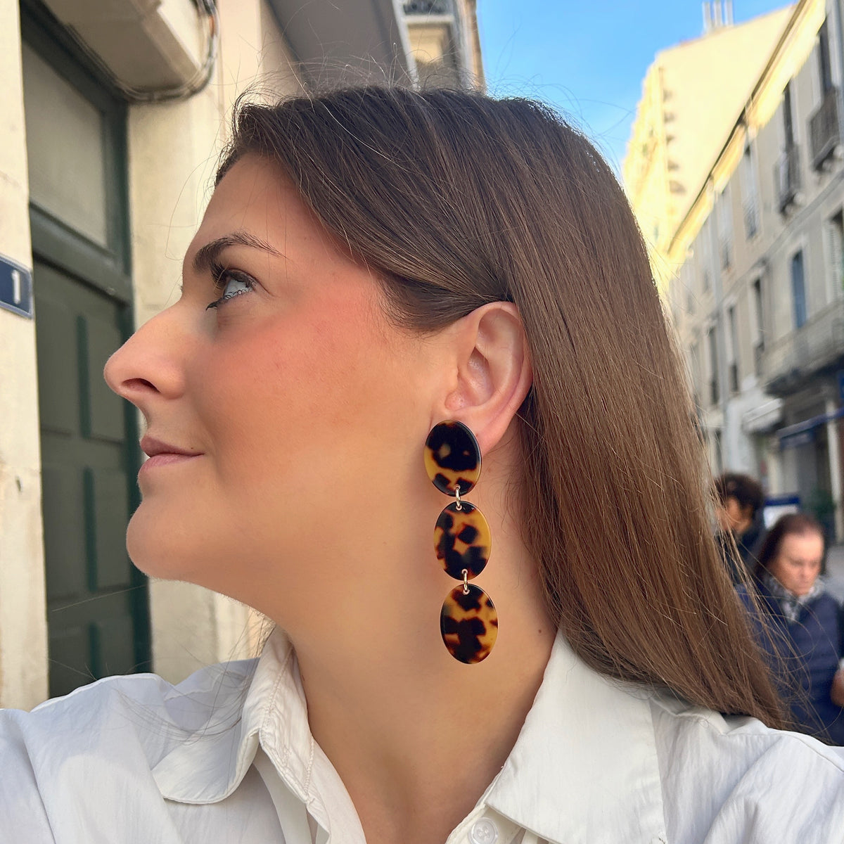 Boucles d’oreilles à clips Solène Écaille de Tokyo Francine Bramli Paris, trois ovales effet écaille marron et ambre reliés par des anneaux dorés.