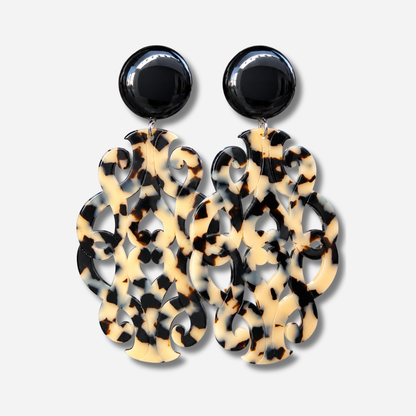 Boucles d’oreilles à clips Sultane XL Écaille Noir et Blanc Francine Bramli Paris, avec cabochon rond noir brillant et grand pendentif baroque ajouré aux motifs écaille noirs et crème.