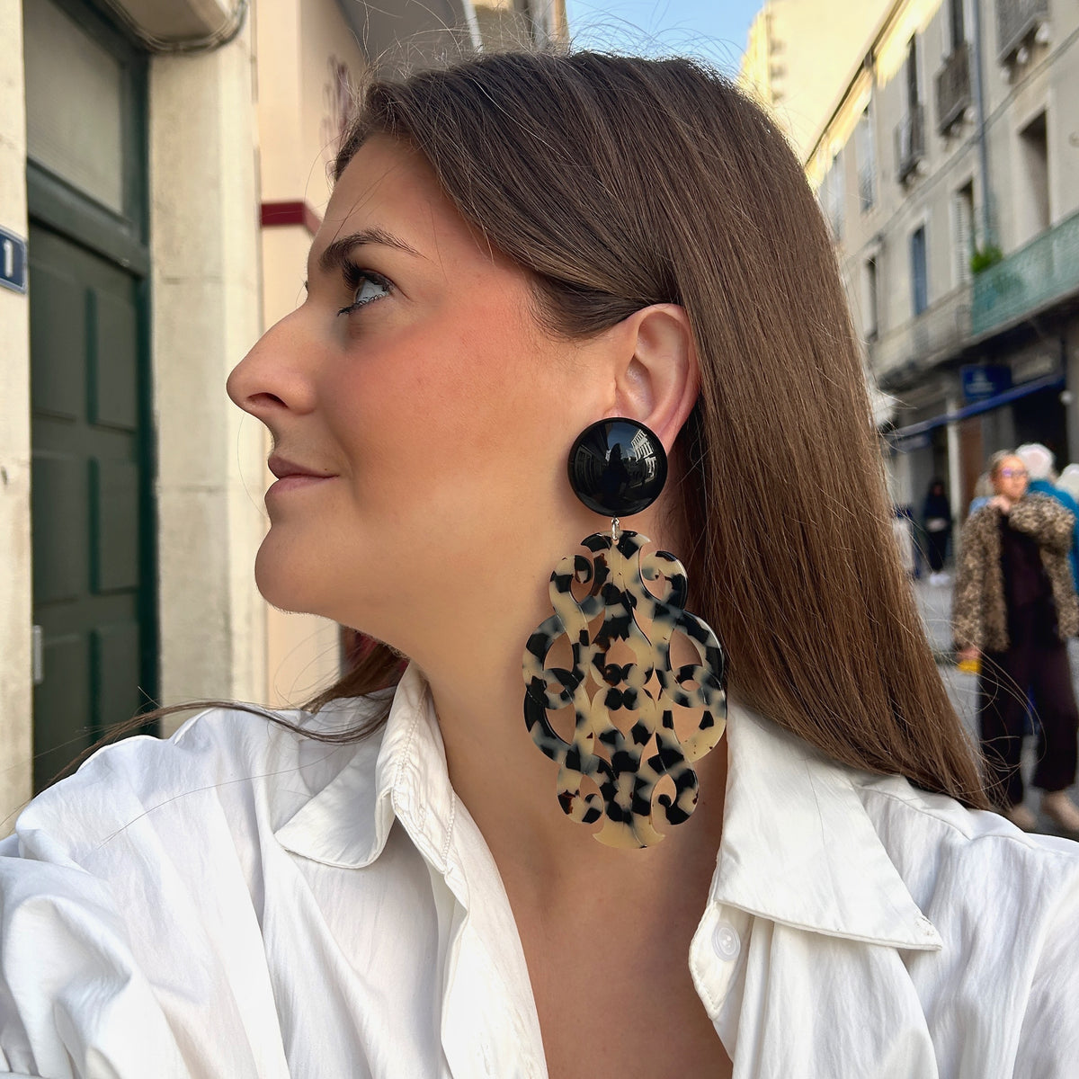 Boucles d’oreilles à clips Sultane XL Écaille Noir et Blanc Francine Bramli Paris, avec cabochon rond noir brillant et grand pendentif baroque ajouré aux motifs écaille noirs et crème.