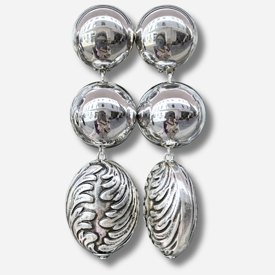Boucles d'oreilles à clips Sumac Silver Francine Bramli Paris, deux sphères argentées effet miroir et grand pendentif ovale argenté aux motifs sculptés en relief – Divinity Sète.