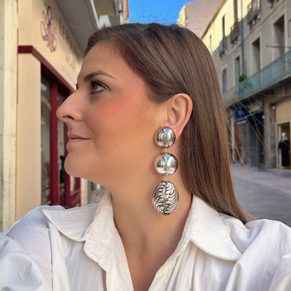Boucles d'oreilles à clips Sumac Silver Francine Bramli Paris, deux sphères argentées effet miroir et grand pendentif ovale argenté aux motifs sculptés en relief – Divinity Sète.