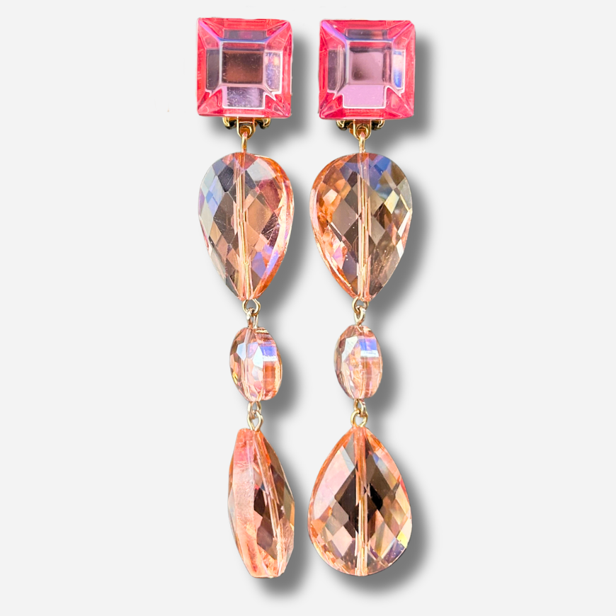 Boucles d'oreilles à clips Suzanna Rose Francine Bramli Paris, attaches carrées en résine rose translucide et pendentifs composés de perles facettées champagne et pêche rosée – Divinity Sète.
