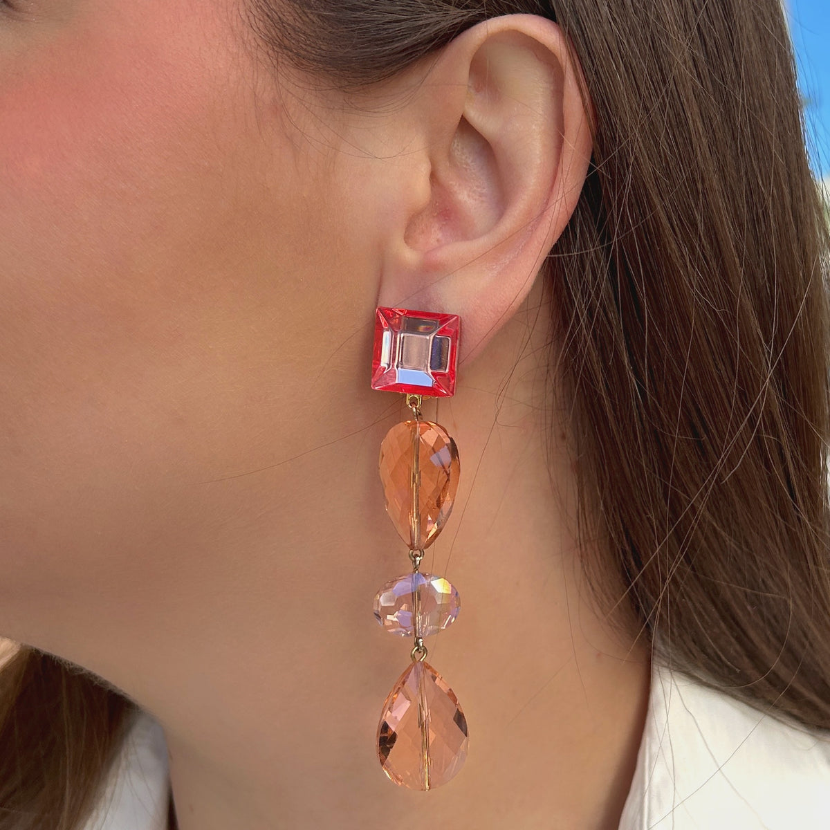 Boucles d'oreilles à clips Suzanna Rose Francine Bramli Paris, attaches carrées en résine rose translucide et pendentifs composés de perles facettées champagne et pêche rosée – Divinity Sète.
